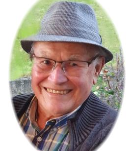 Lächelnder älterer Mann mit Brille und Hut, Porträt vor grünem Hintergrund.