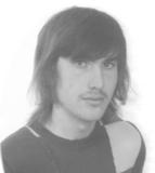 Schwarz-weiß Porträt eines Mannes mit langen Haaren und einem gestreiften Pullover, der leicht zur Seite schaut.