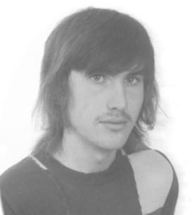 Schwarz-weiß Porträt eines Mannes mit langen Haaren und einem gestreiften Pullover, der leicht zur Seite schaut.