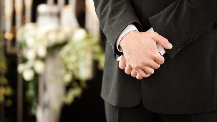 Person mit verschränkten Armen vor Kerzen Person mit verschränkten Armen vor Kerzen